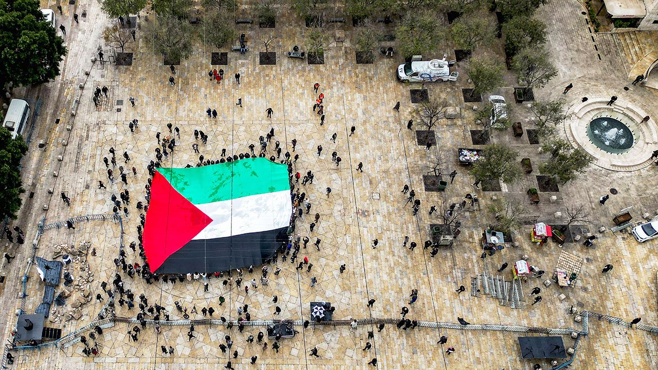 This aerial view shows people with a giant Palestinian flag in Manger Square, Bethlehem