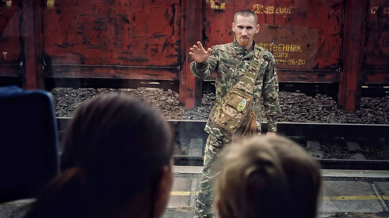 A Ukrainian soldier waves goodbye to his family at the railroad station in Kramatorsk, Ukraine