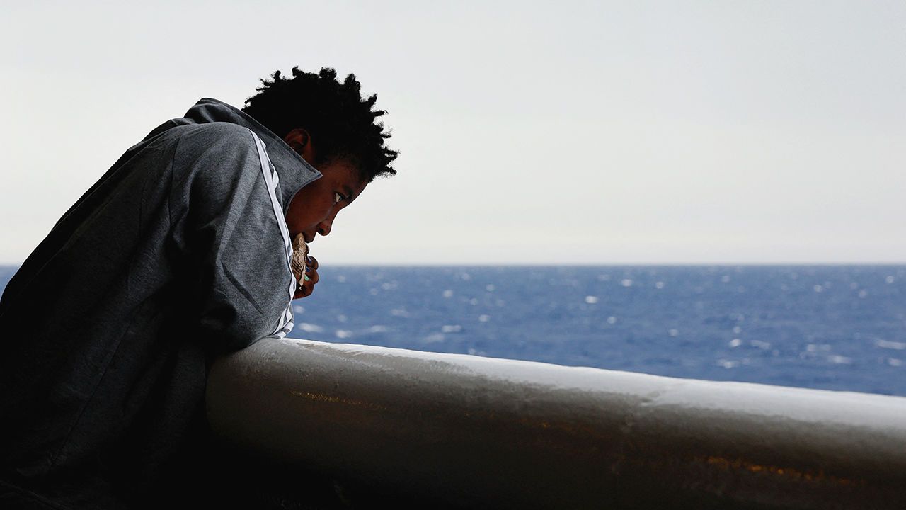 A migrant looks at the sear from a rescue ship in the Mediterranean sea