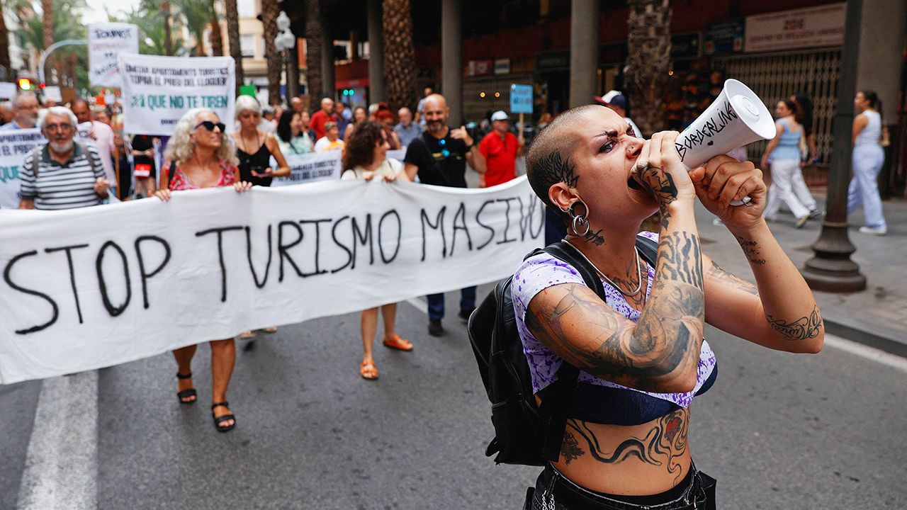 A demonstrator uses a megaphone as people protest against mass tourism, in Alicante, Spain, July 13th 2024